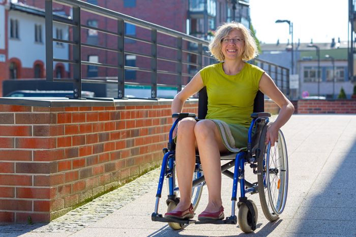 woman seated in a wheelchair riding down a ramp